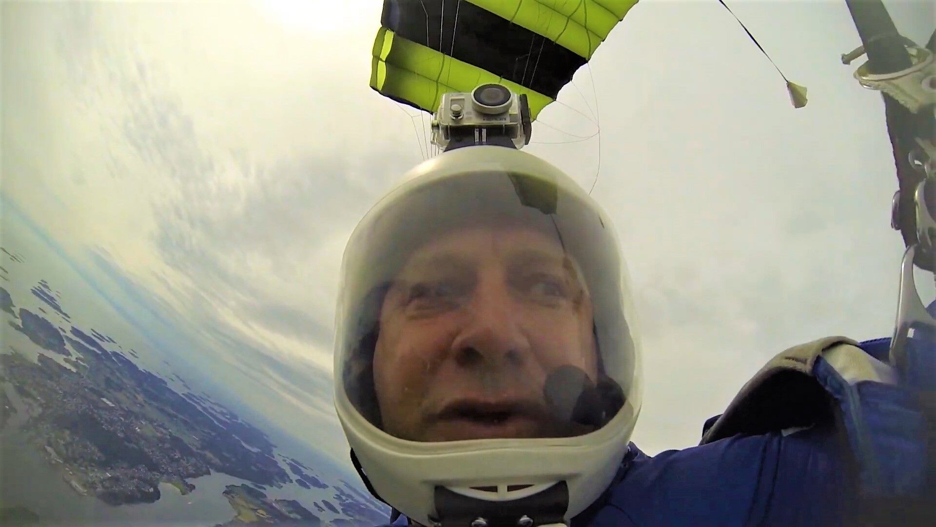 Brian Germain under canopy, a coastline far below